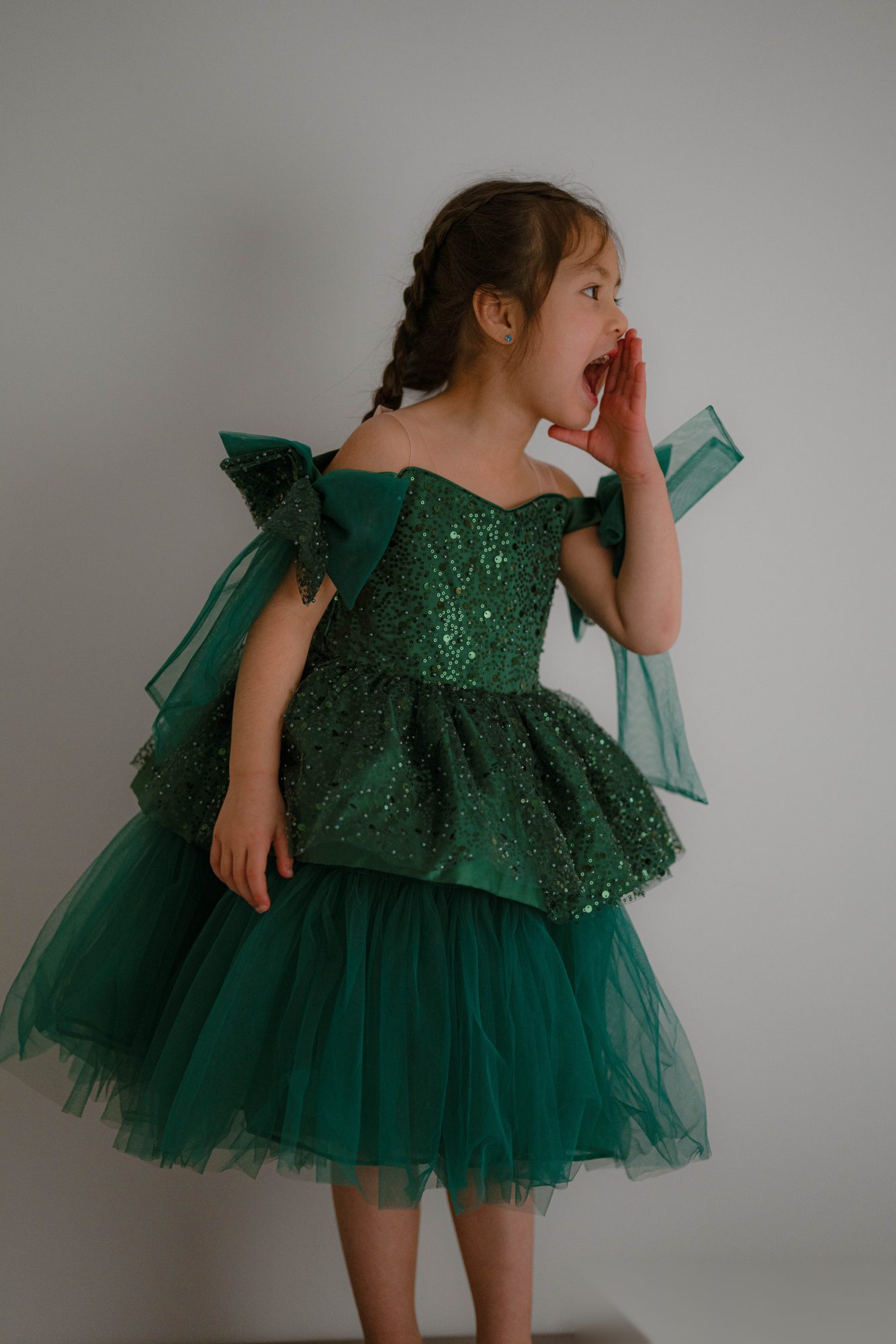 Enfant en robe de fête verte qui appelle joyeusement — photographie d'enfance à Nancy